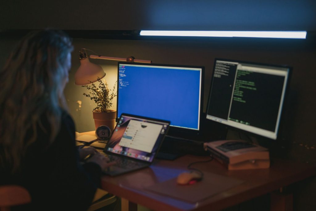 Cybersecurity professional reviewing terminal output on a dual-monitor workstation