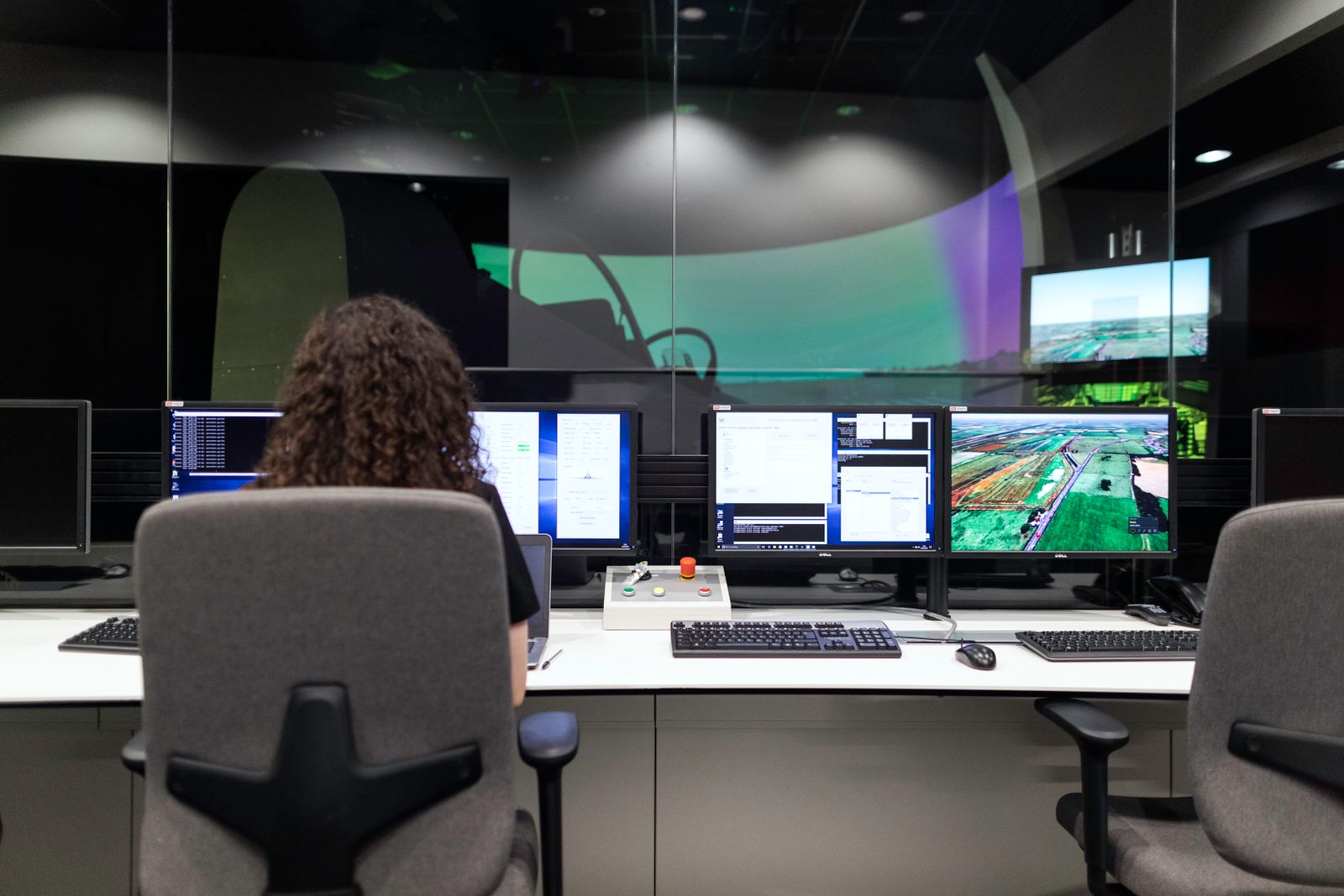 Analyst monitoring multiple screens in a control room